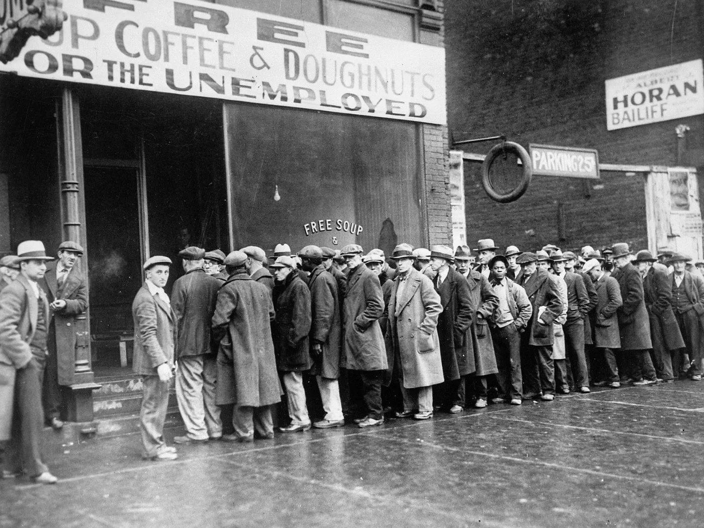Fila de desempregados por sopa, café e rosquinhas gratuitos em Chicago, durante a Grande Depressão que se seguiu ao crash de 1929. Foto: Arquivo Nacional dos EUA, domínio público.